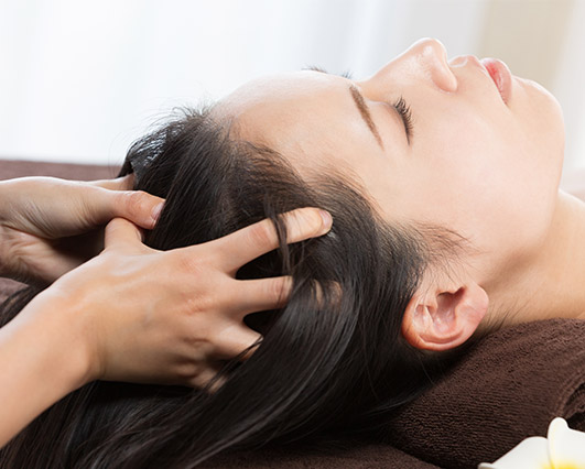 Woman receiving a relaxing scalp massage at Sunflower Spa in Longmont, CO