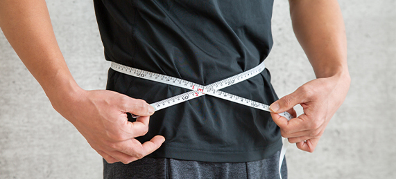 Man measuring his waist at Sunflower Spa